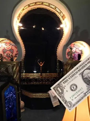 Arched chapel alcove with a crucifix, shown beside a dollar bill for scale