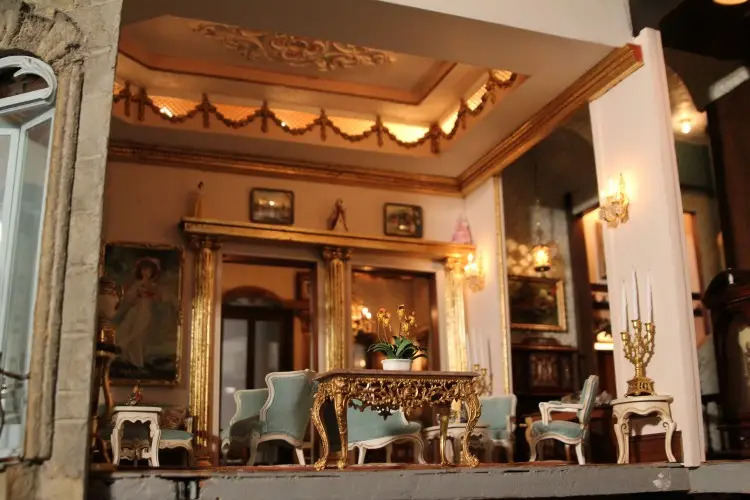 Formal drawing room with pale blue chairs, gilded mirrors and candlesticks
