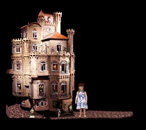 The Astolat Dollhouse Castle next to a young girl, showing its full height