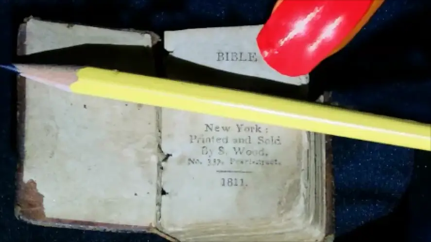Tiny antique Bible printed in New York in 1811, beside a pencil tip for scale