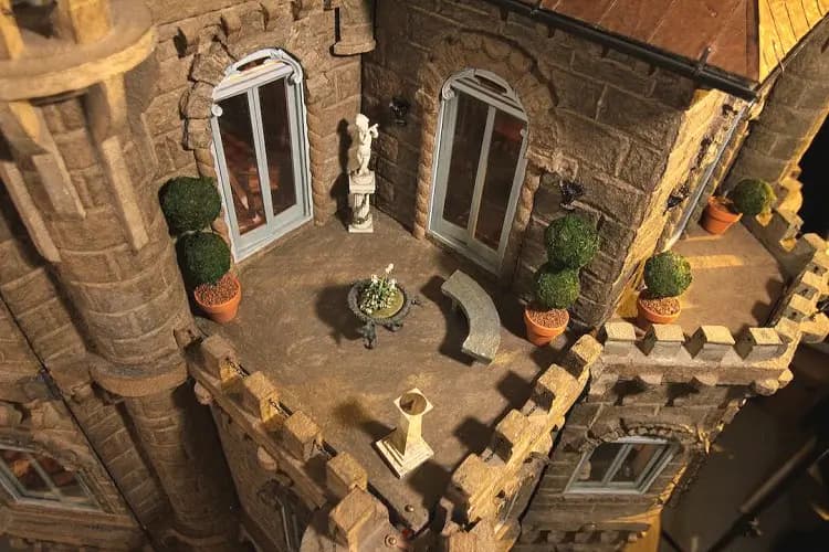 Stone courtyard terrace with topiary, a statue and a fountain