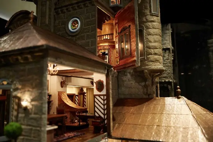Castle rooftops and a tower room lit at night